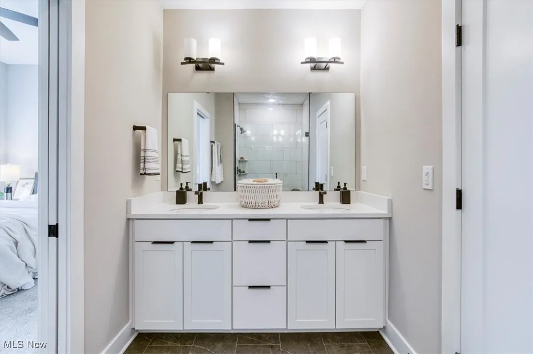 Full bath with ensuite bathroom, a shower stall, and double vanity