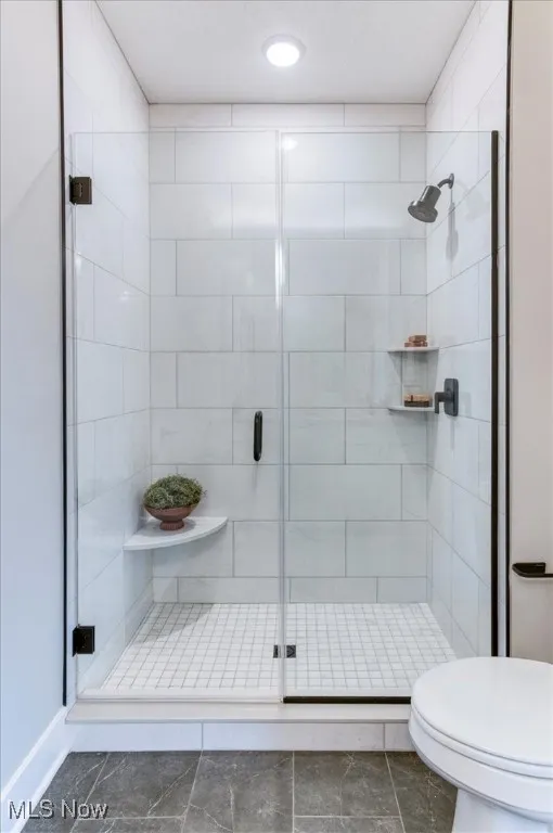Bathroom with a stall shower, marble finish floors, and recessed lighting