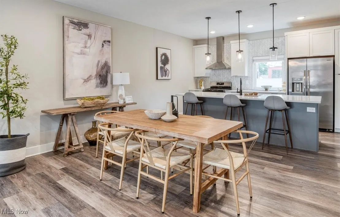 Dining room with light wood finished floors and recessed lighting
