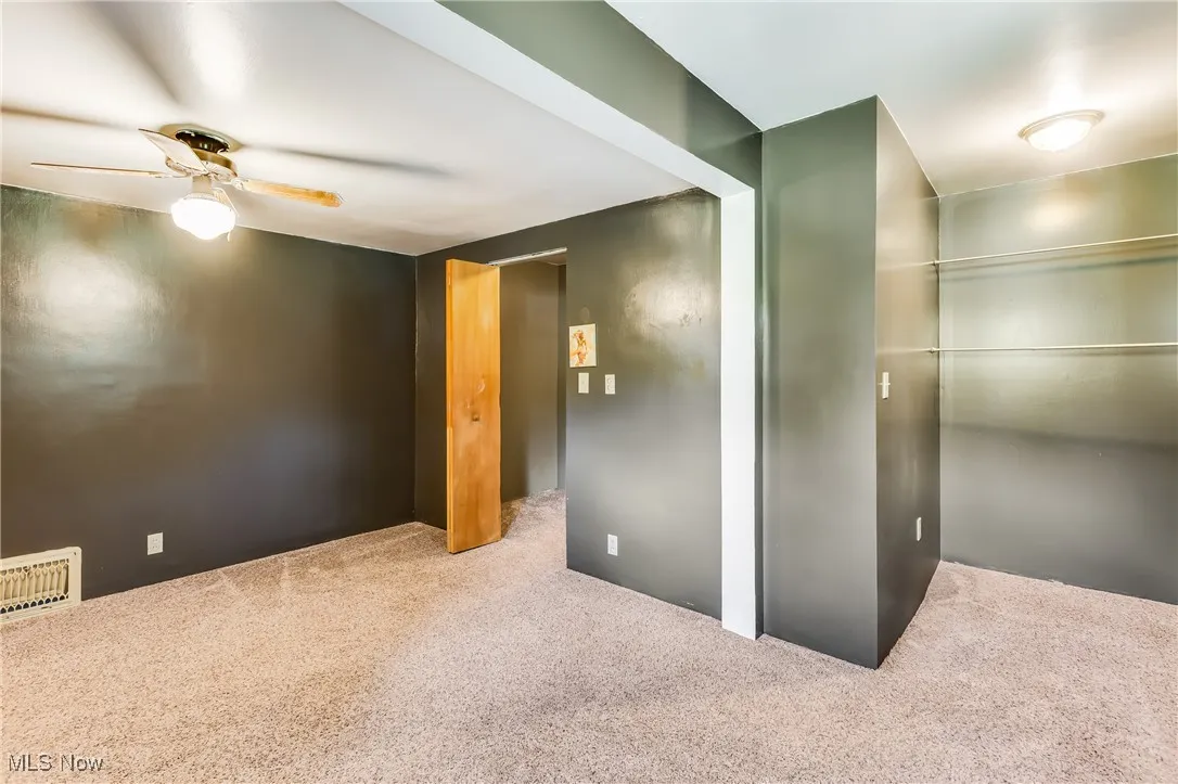 Unfurnished room featuring carpet and a ceiling fan