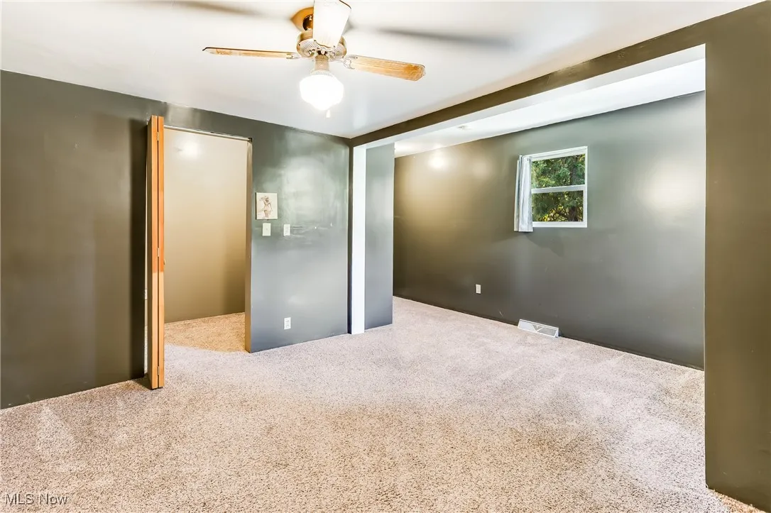 Spare room with carpet flooring and ceiling fan
