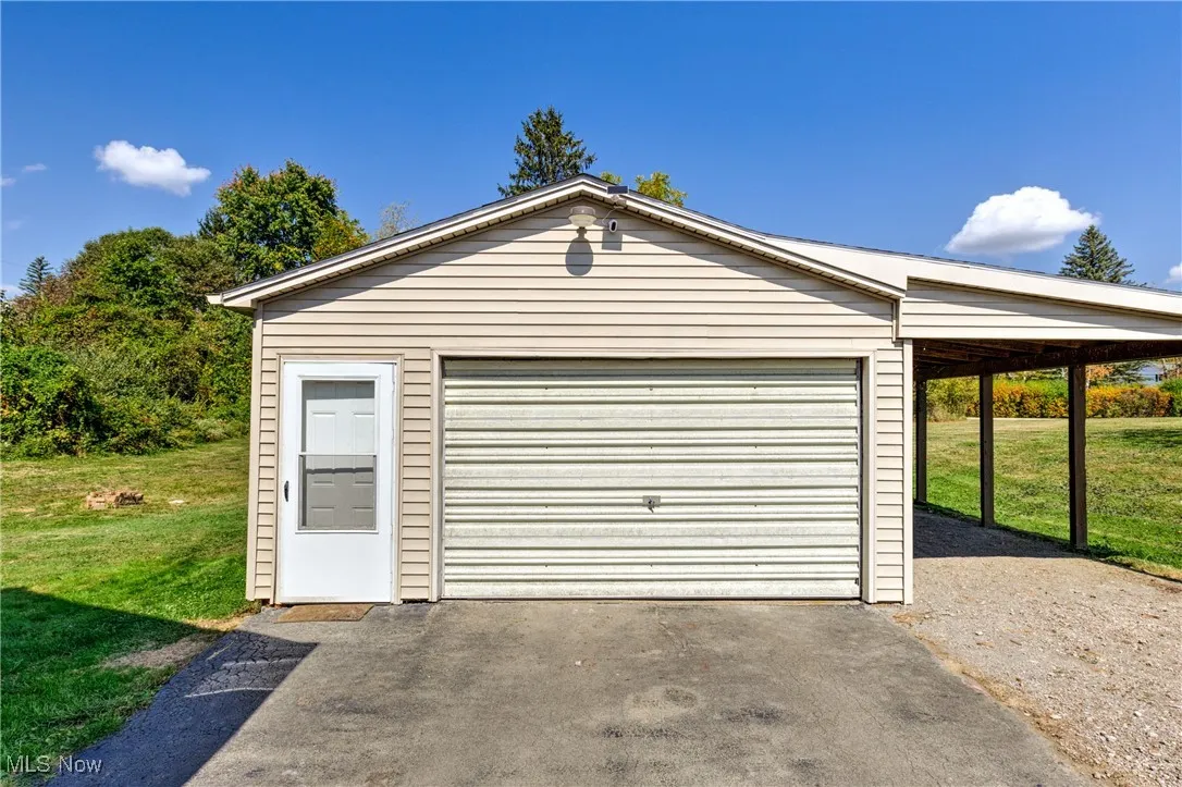 Garage featuring a detached garage and driveway