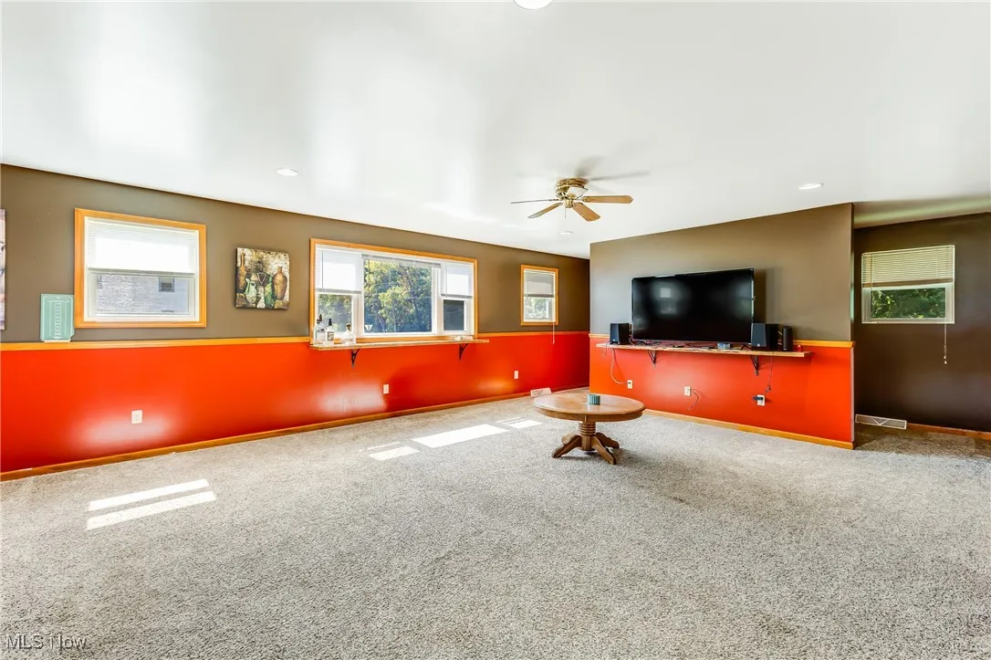 Living area with carpet flooring, plenty of natural light, recessed lighting, and ceiling fan