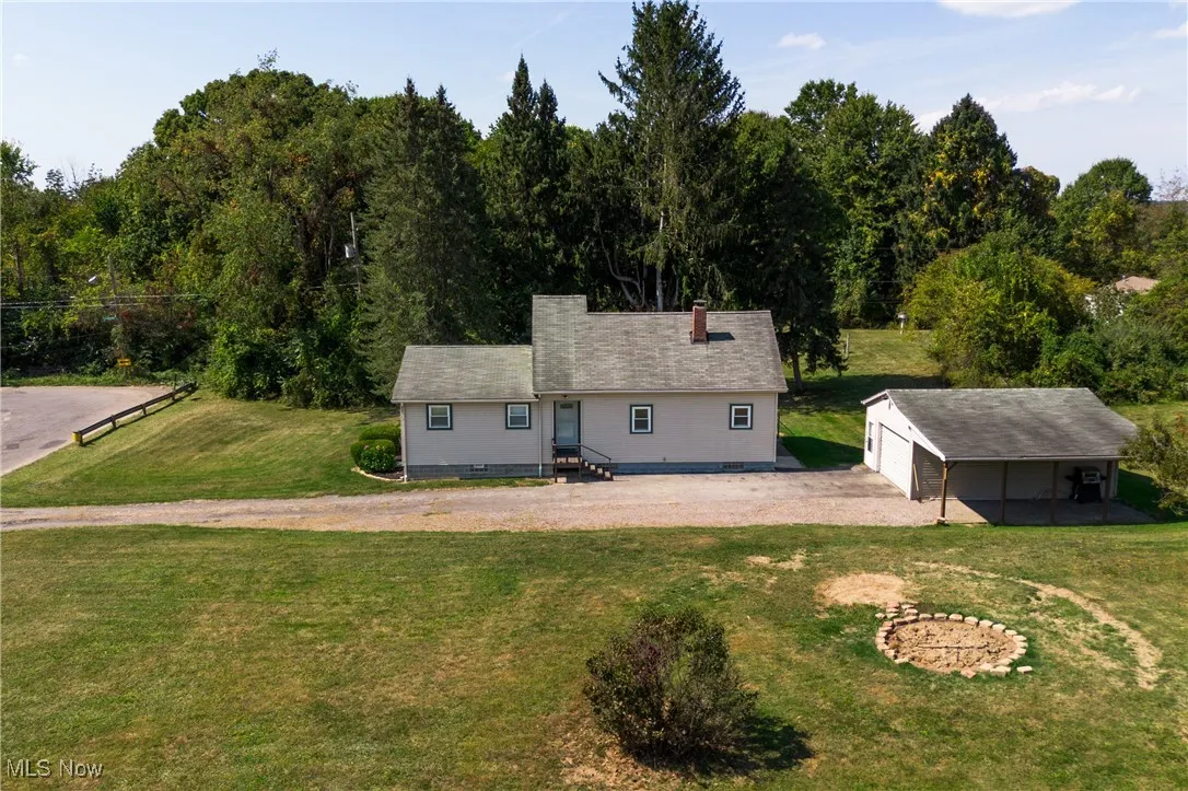 Back of house with an outdoor structure, a yard, and crawl space