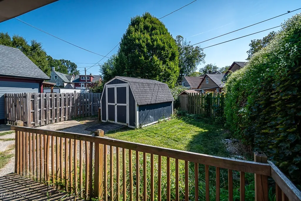 Wooden deck with a fenced backyard and a storage shed