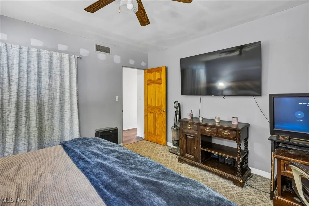 Bedroom with light carpet and ceiling fan
