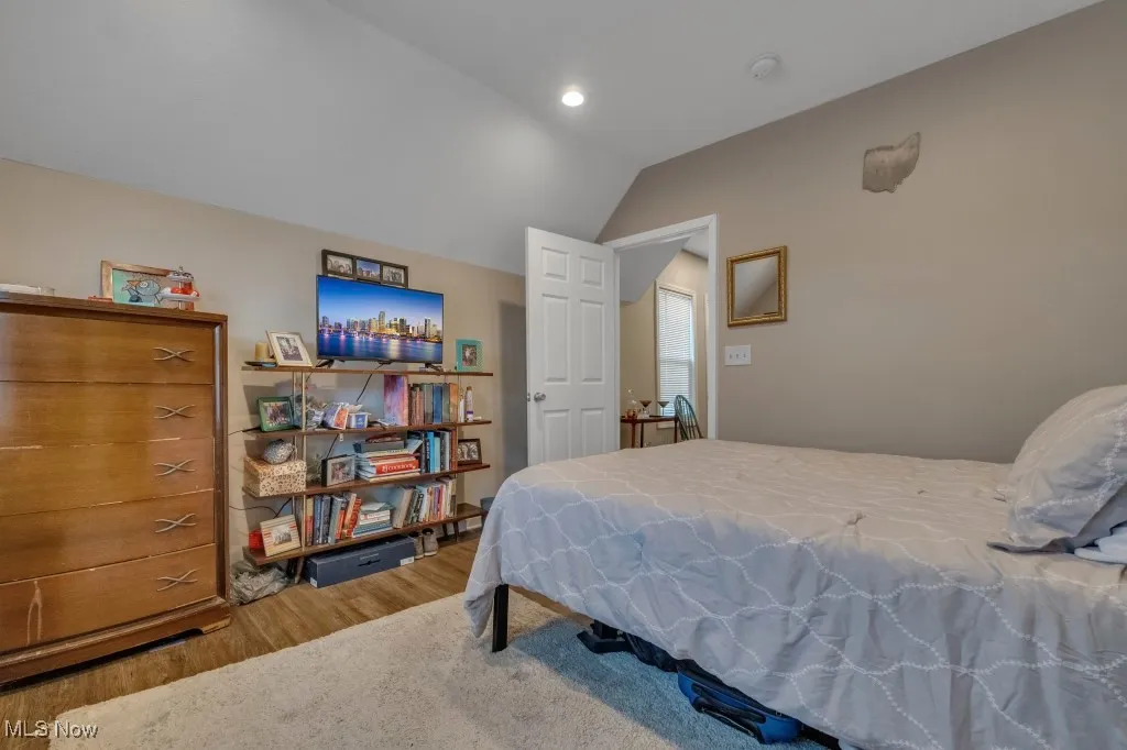 Bedroom with vaulted ceiling, light wood-style floors, and recessed lighting