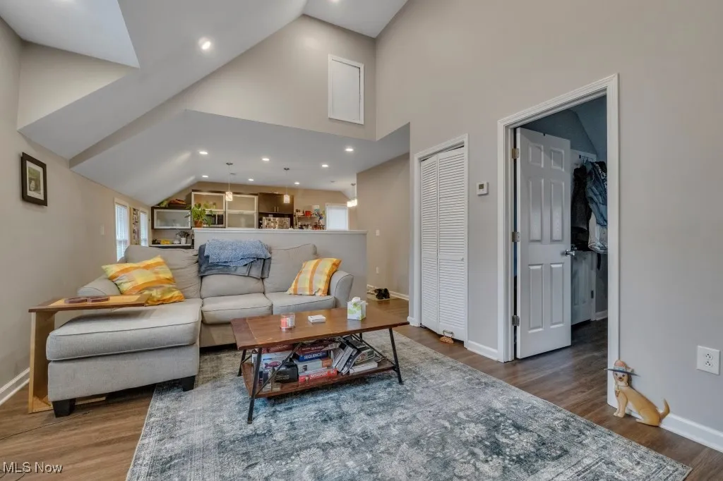 Living area featuring recessed lighting, dark wood-style floors, and high vaulted ceiling