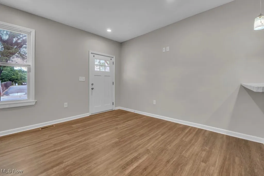 Entrance foyer with wood finished floors and recessed lighting
