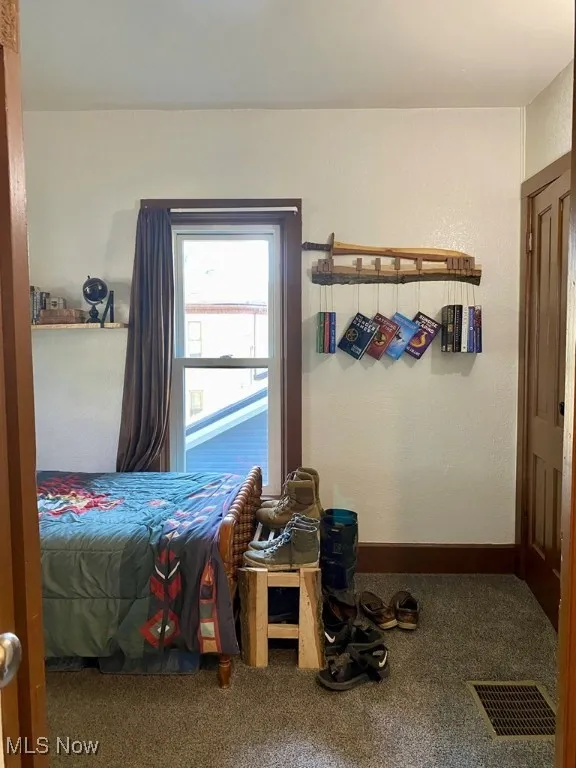 Bedroom featuring carpet and a textured wall