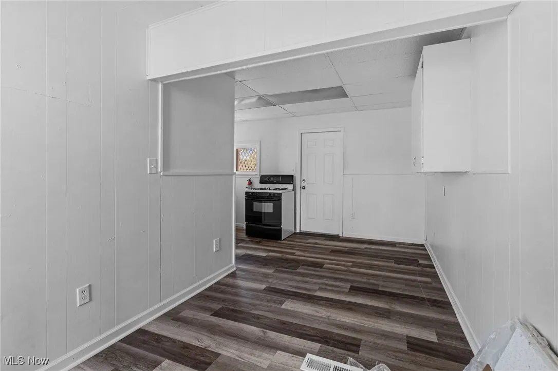 Hall featuring dark wood-style flooring and wooden walls