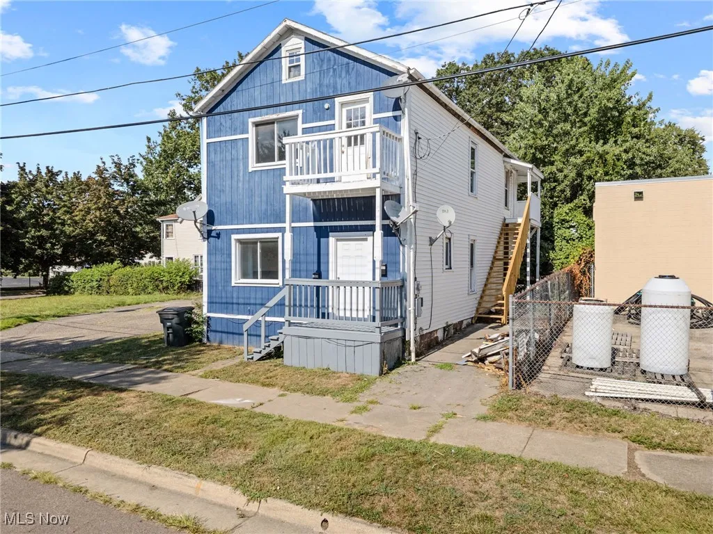 View of front of home with a balcony and stairway