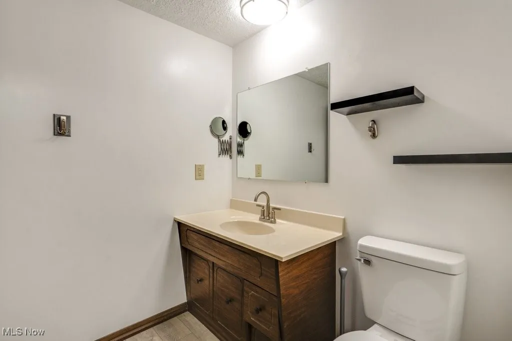 Half bathroom with vanity and a textured ceiling