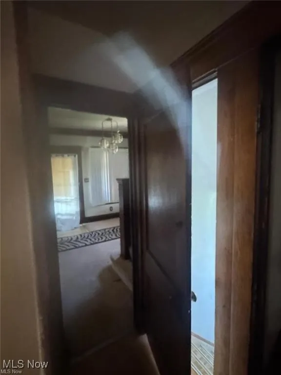 Hallway featuring a chandelier and carpet