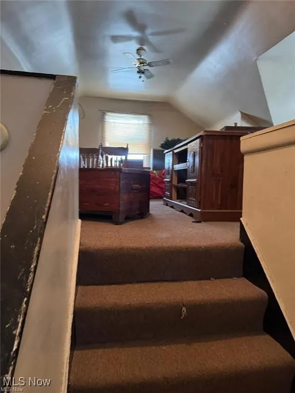Stairway featuring carpet, vaulted ceiling, and ceiling fan