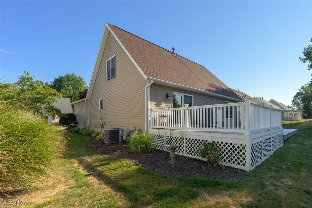 Rear view of property with a deck and a yard