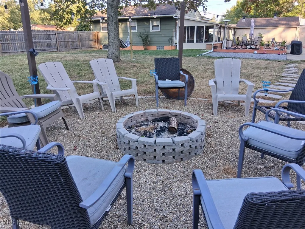 View of yard with an outdoor fire pit, a patio area, and a sunroom