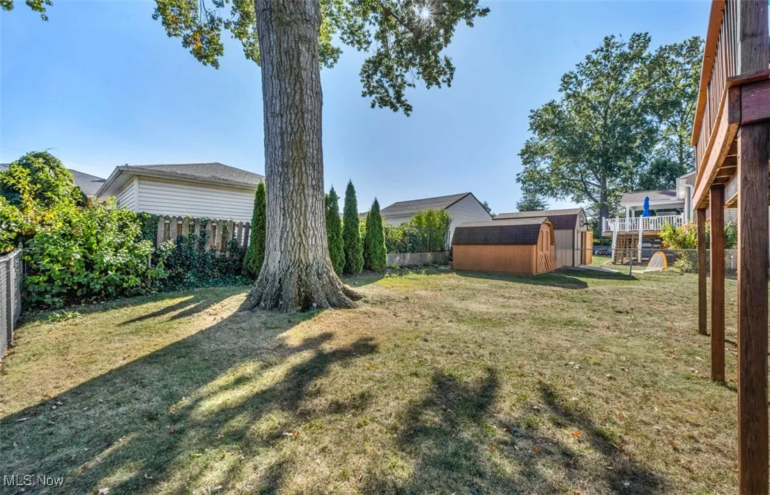 Fenced backyard featuring a storage shed