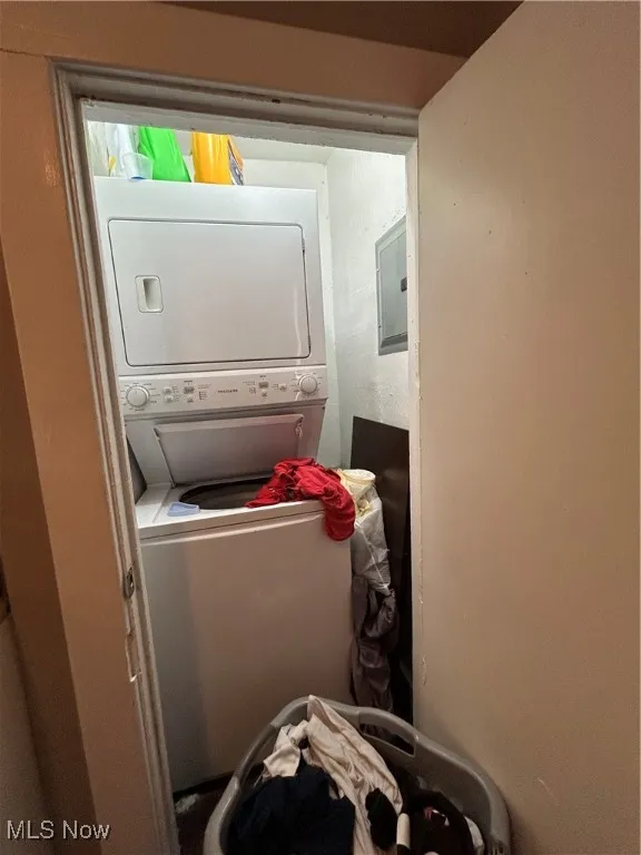 Washroom featuring stacked washer / dryer and electric panel