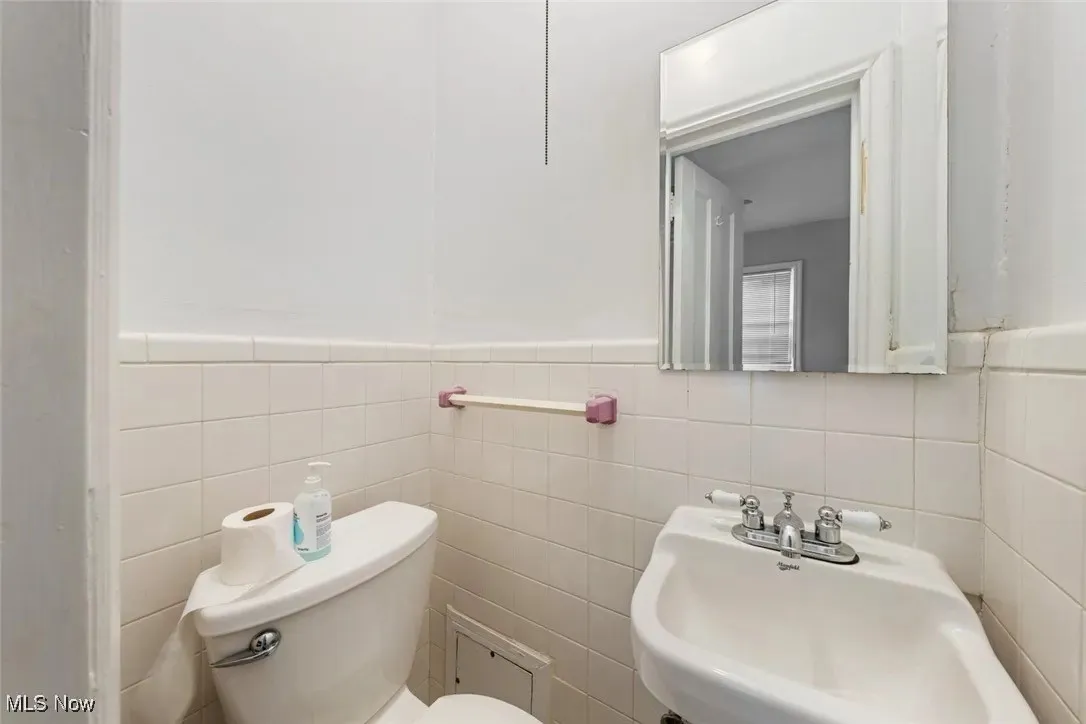 Bathroom featuring tile walls and a wainscoted wall