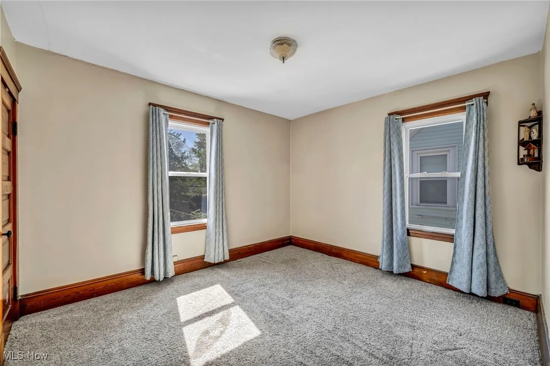 Spare room with light carpet and baseboards