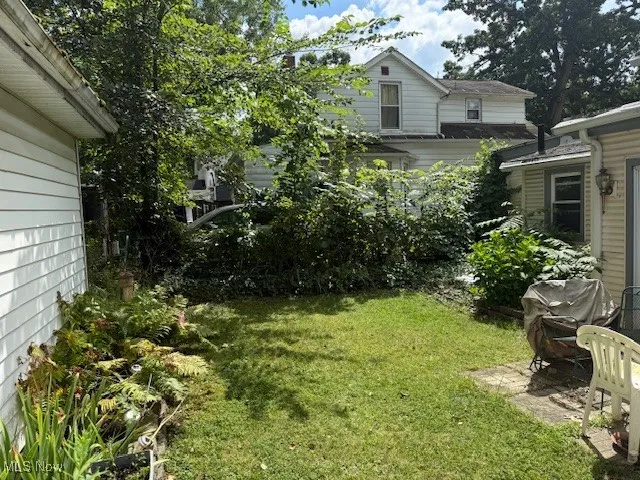 View of green lawn with a patio area