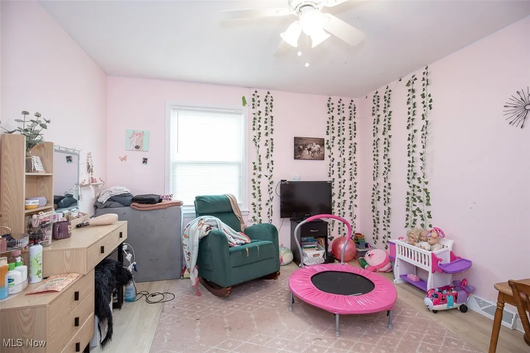 Recreation room with light wood finished floors and a ceiling fan