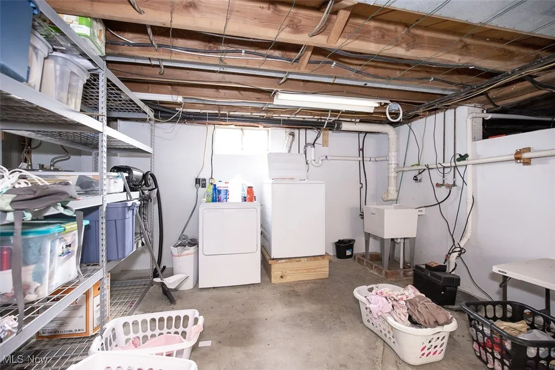 Unfinished below grade area with washer and clothes dryer