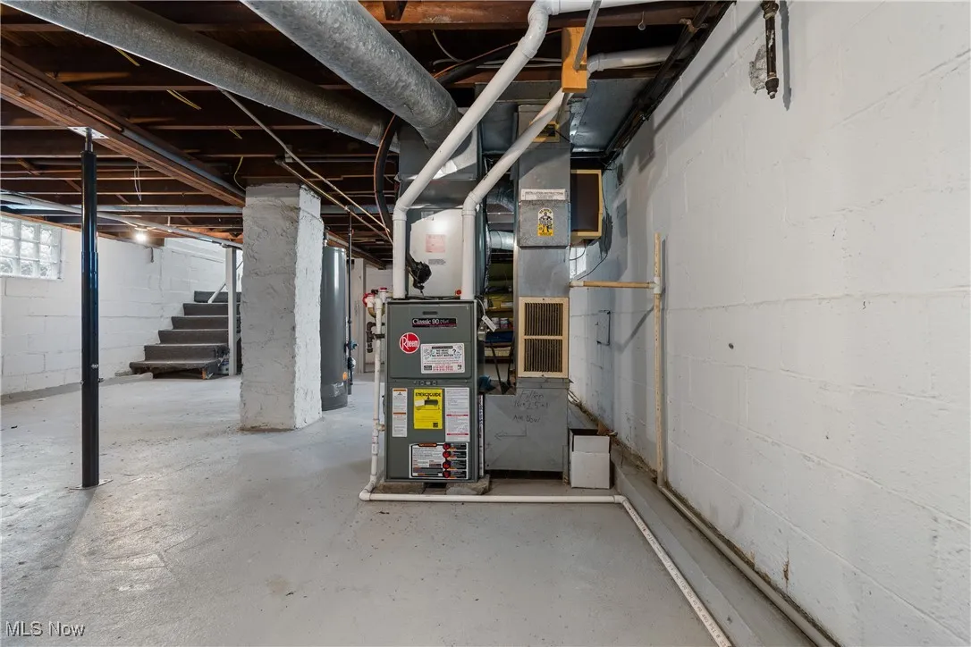 Below grade area featuring water heater and stairs