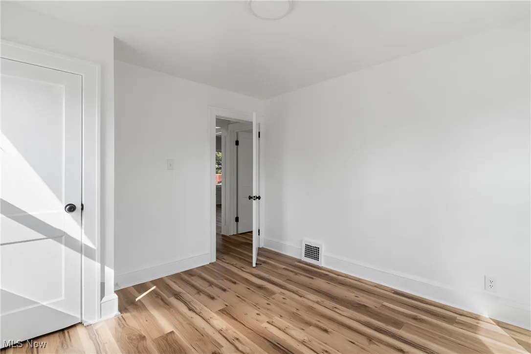 Spare room featuring baseboards and light wood finished floors