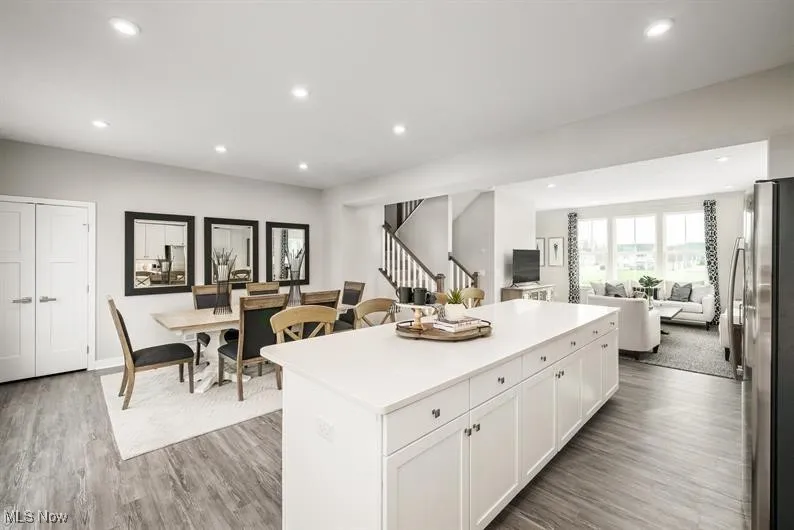 Kitchen featuring open floor plan, freestanding refrigerator, recessed lighting, white cabinetry, and light wood-type flooring