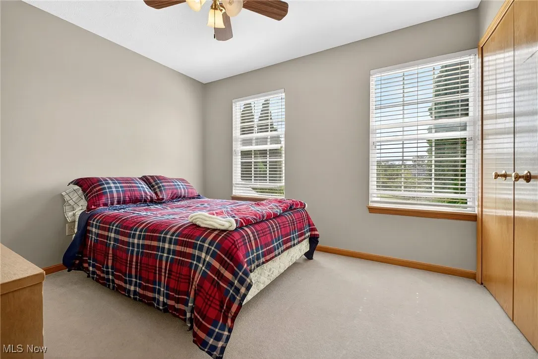 Bedroom featuring light carpet and a ceiling fan