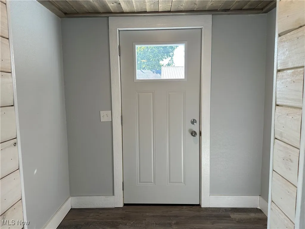 Doorway with wood finished floors and wood ceiling