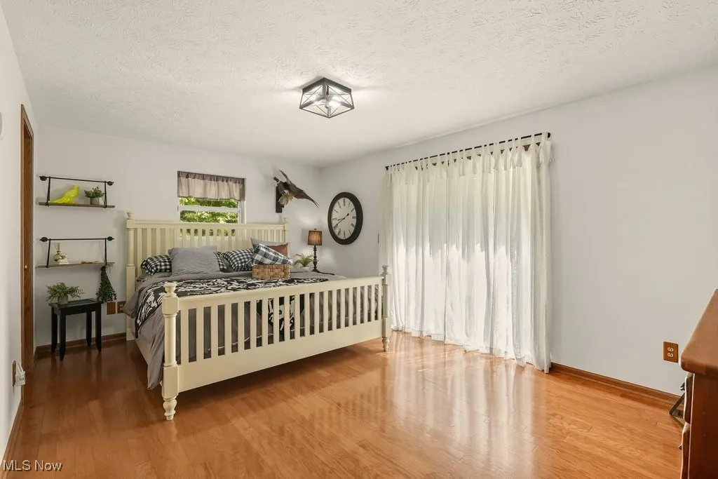Bedroom with a textured ceiling and light wood-style flooring