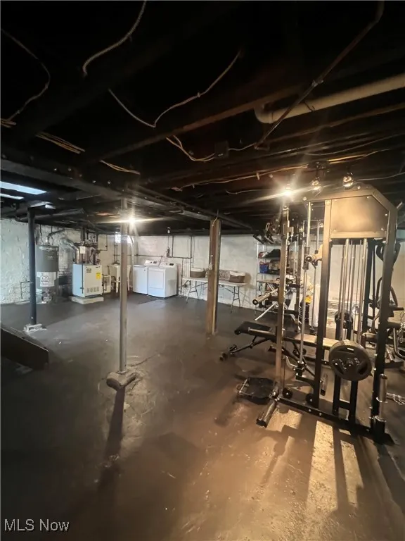 Unfinished basement with water heater and separate washer and dryer