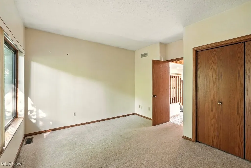 Unfurnished bedroom with carpet, a closet, and a textured ceiling
