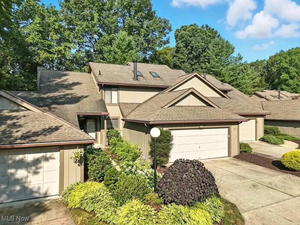 View of front of home featuring a shingled roof, a garage, and concrete driveway