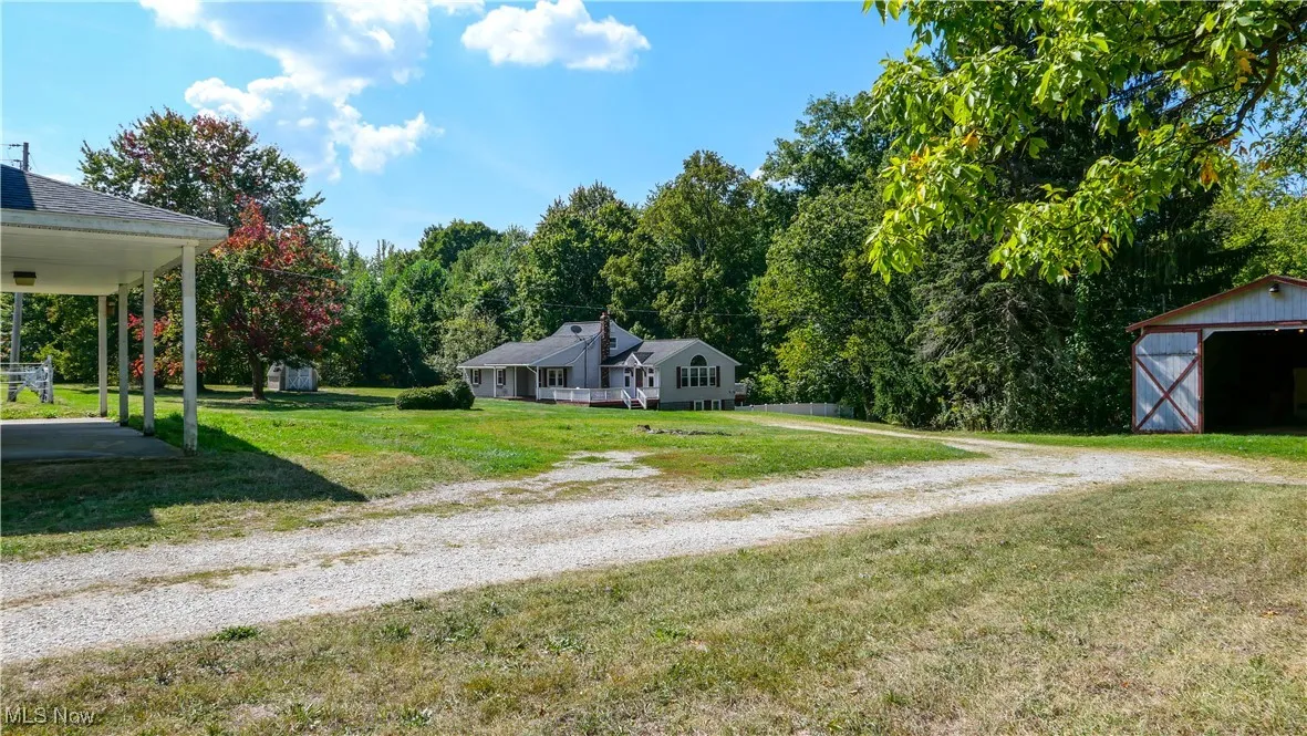View of dirt / gravel driveway with a wooded view