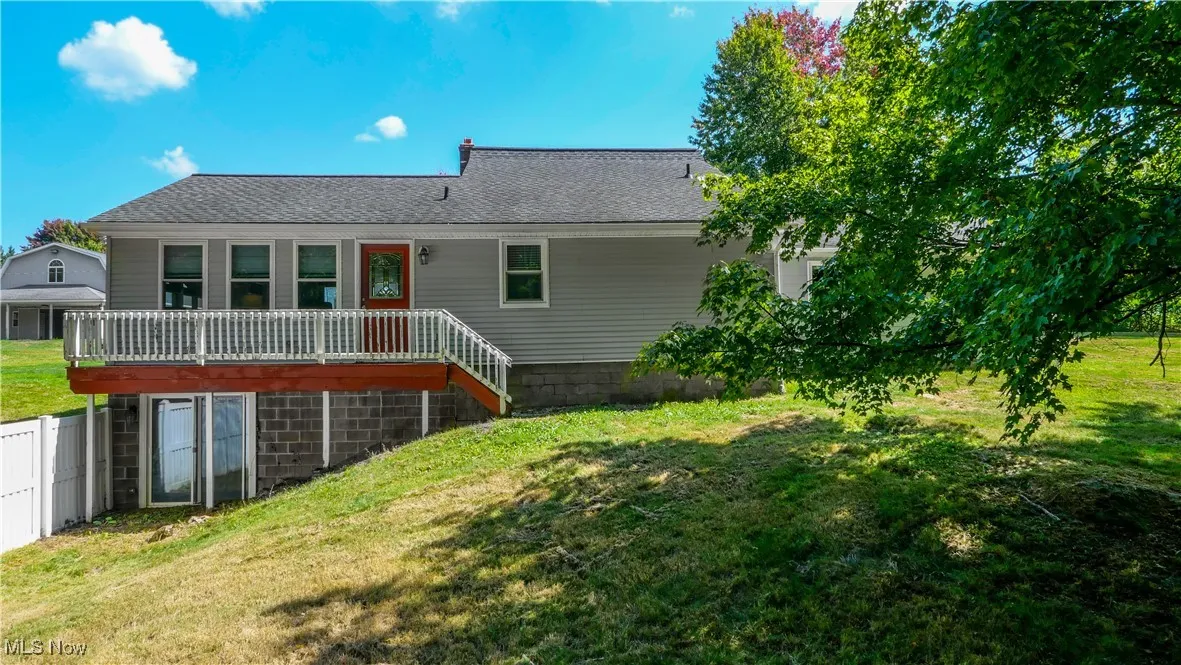 Back of property with a yard and a shingled roof
