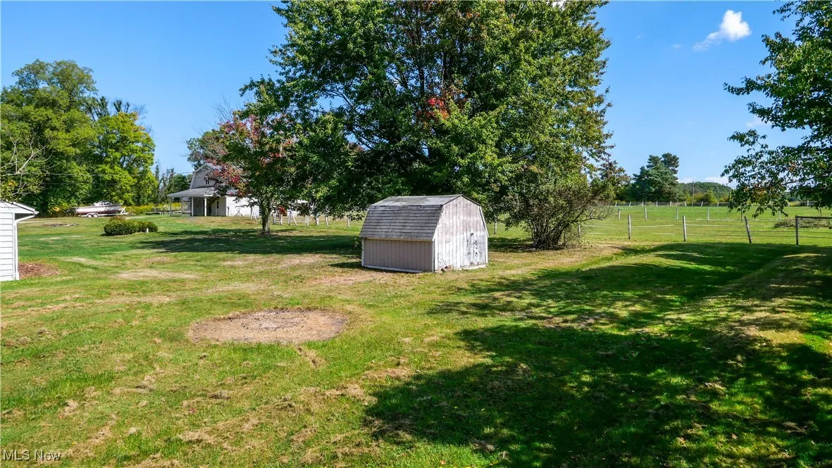 View of green lawn featuring a shed
