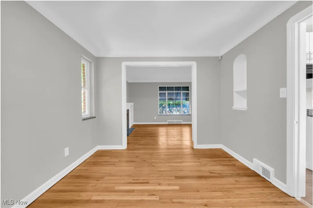 Hall with light wood-style floors and ornamental molding