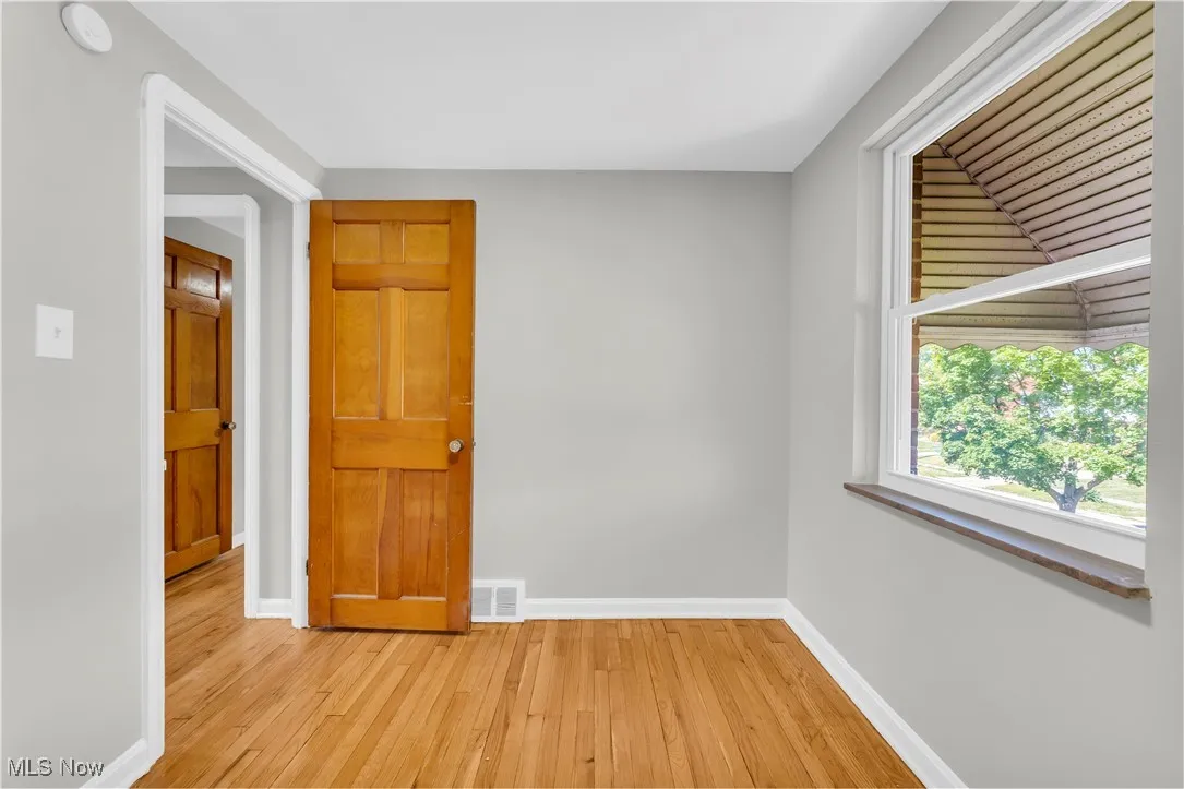 Spare room featuring wood-type flooring and baseboards