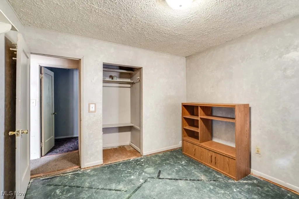 Unfurnished bedroom with a textured ceiling and a closet
