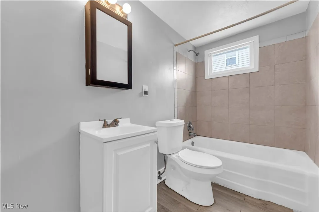 Full bathroom with  shower combination, vanity, and light wood-style floors