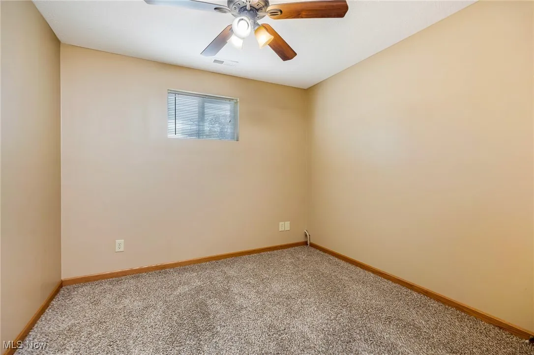 Empty room with carpet floors and ceiling fan