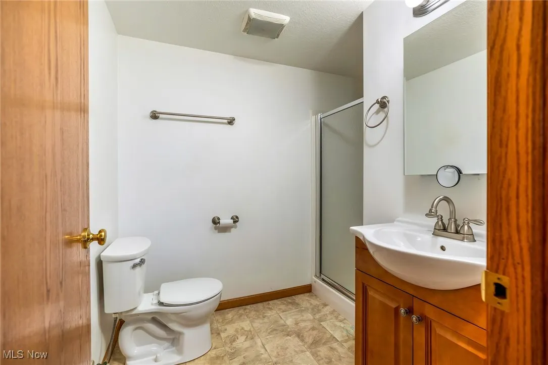 Bathroom featuring a shower stall and vanity