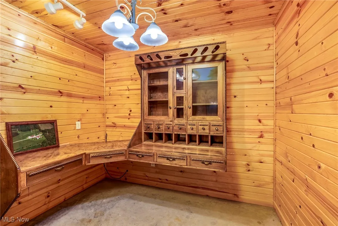 Relaxing sauna with wooden walls, wood ceiling, and concrete flooring