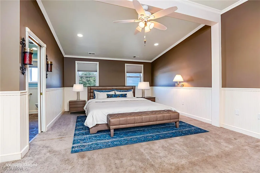 Carpeted bedroom featuring ornamental molding, wainscoting, recessed lighting, and a ceiling fan
