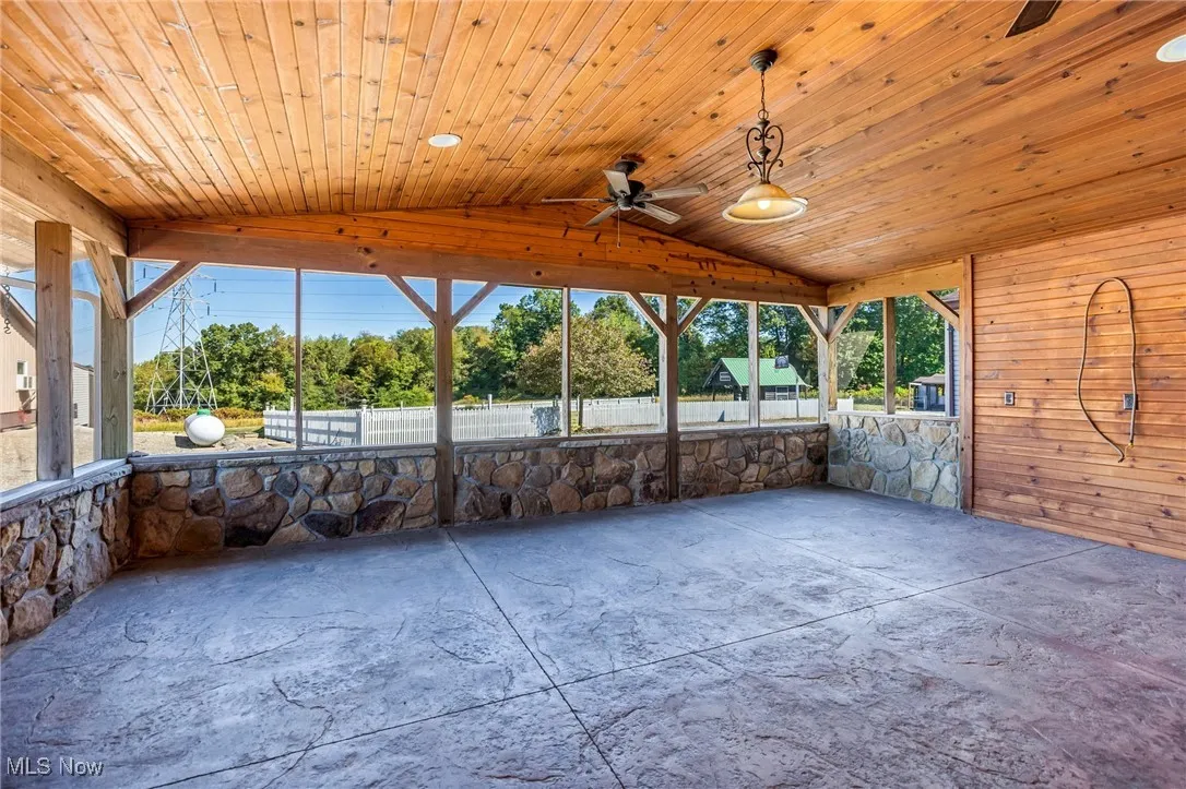 Unfurnished sunroom featuring lofted ceiling