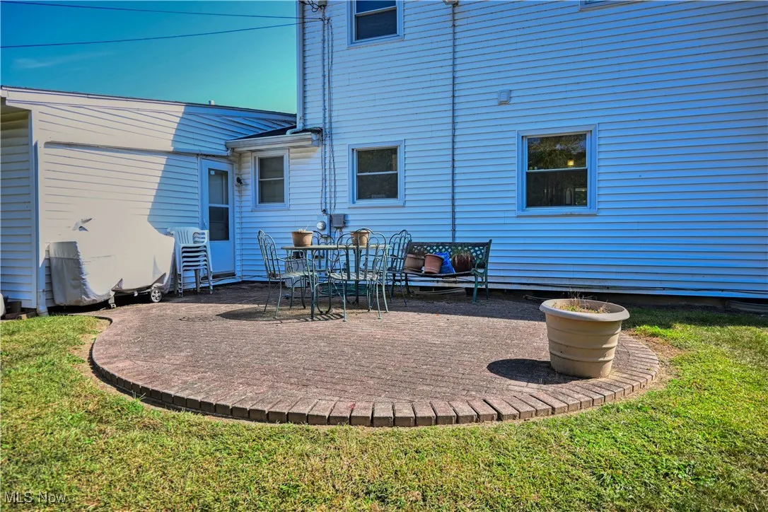 Rear view of house with a patio and a yard
